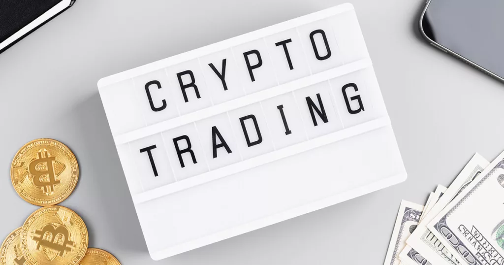 An image showing a paper with crypto trading letters placed on it along side some gold crypto coins and dollar bills.